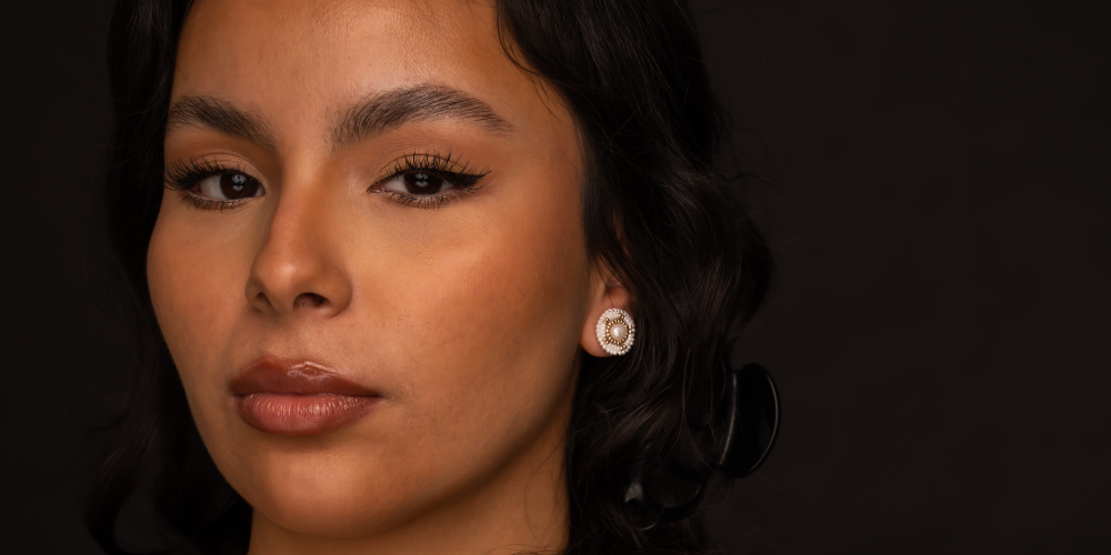 Woman wearing small beaded earrings featuring a small white freshwater pearl center