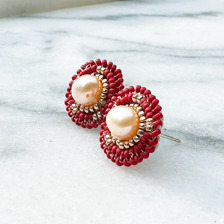 Red Handmade Seed Bead Earrings photographed sitting on a marble background. 