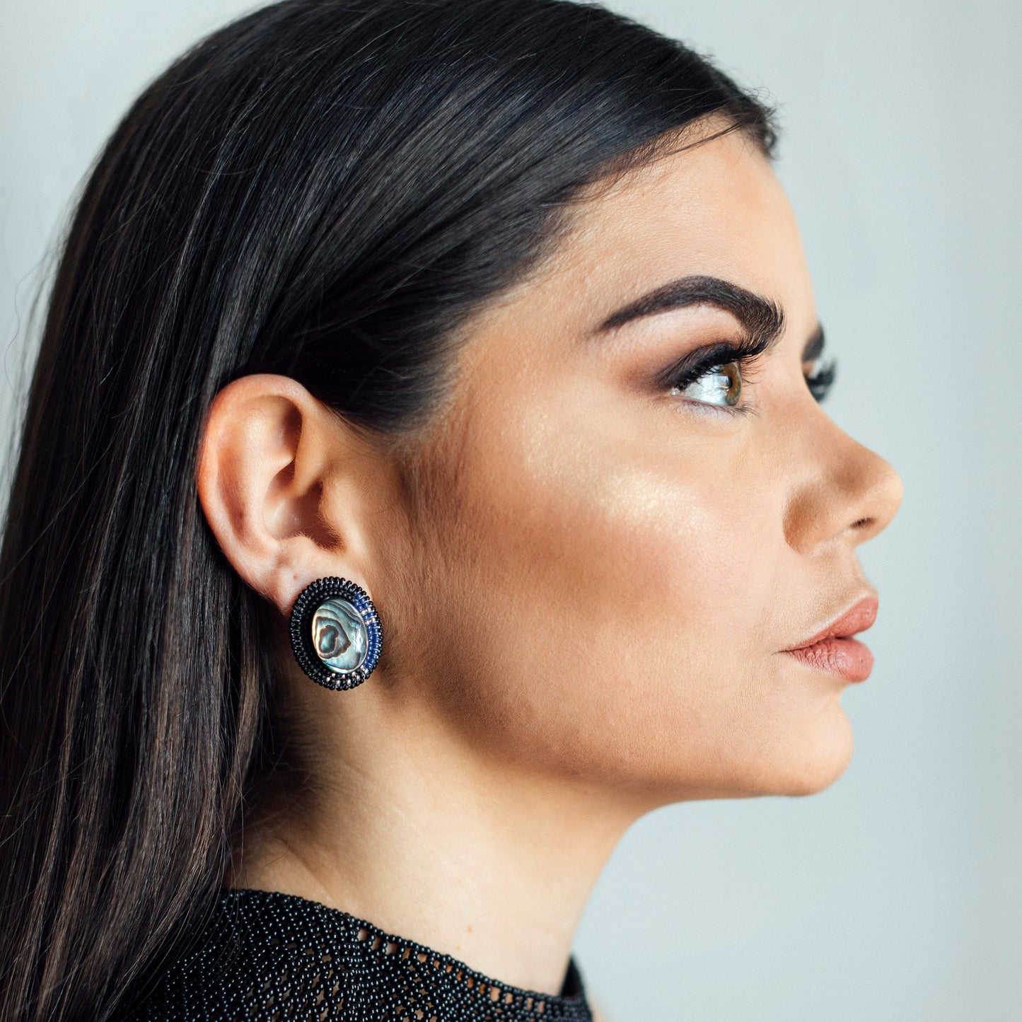 Model Wearing Cheyanne Symone’s Raven Abalone Statement Earrings | Glass Beads Wrapped Around an Abalone Shell Center